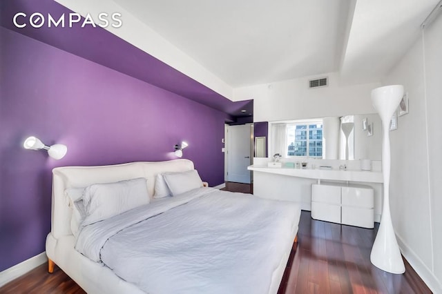 bedroom with baseboards, visible vents, and dark wood finished floors
