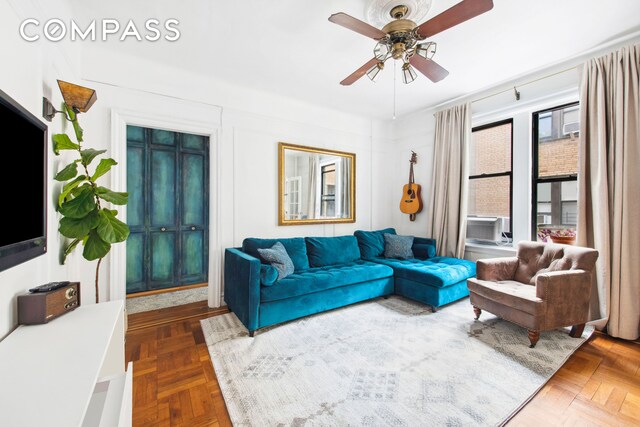 living room with ceiling fan and dark parquet floors