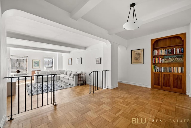 corridor featuring light parquet flooring, built in features, and beam ceiling