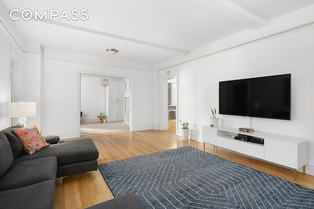 living room featuring beamed ceiling and wood-type flooring