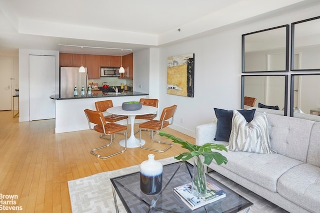 living area featuring light wood finished floors and baseboards