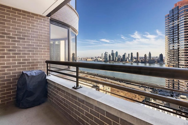 balcony with a city view, a grill, and a water view