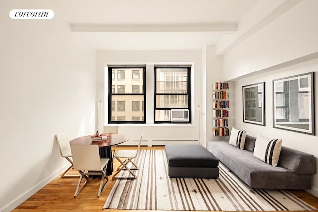 sitting room with hardwood / wood-style floors, beam ceiling, and baseboard heating