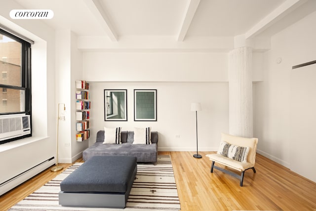 living room featuring beamed ceiling, a baseboard heating unit, and hardwood / wood-style floors