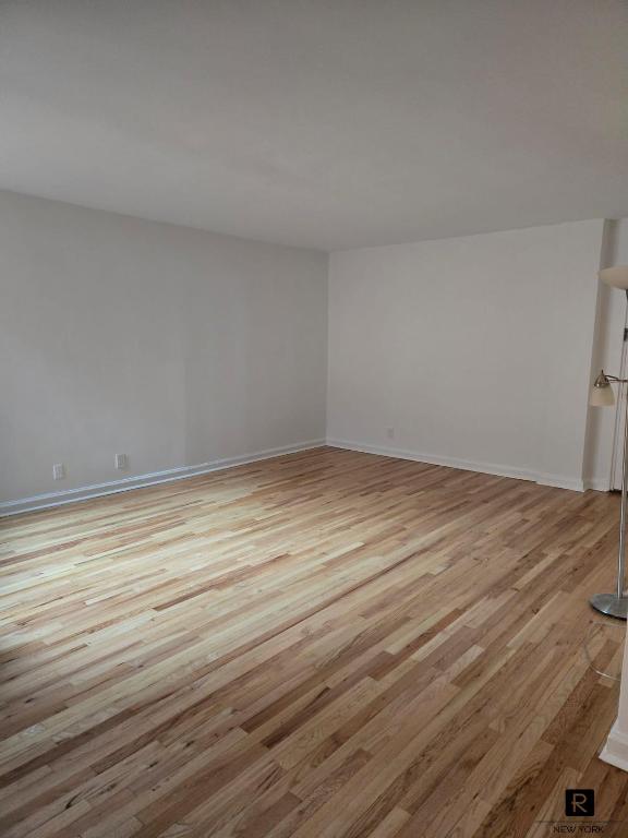 empty room featuring light wood-style floors and baseboards