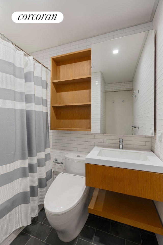 bathroom featuring toilet, tile walls, vanity, and tile patterned flooring