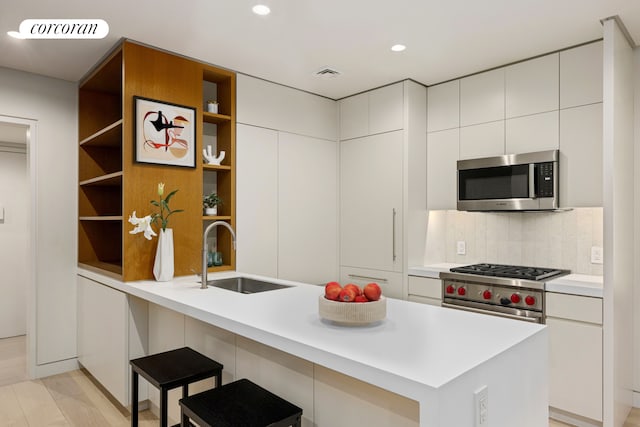 12 W 72nd St Unit 3Kl, New York City, NY 10023 - kitchen featuring stainless steel appliances, a sink, open shelves, light countertops, and recessed lighting