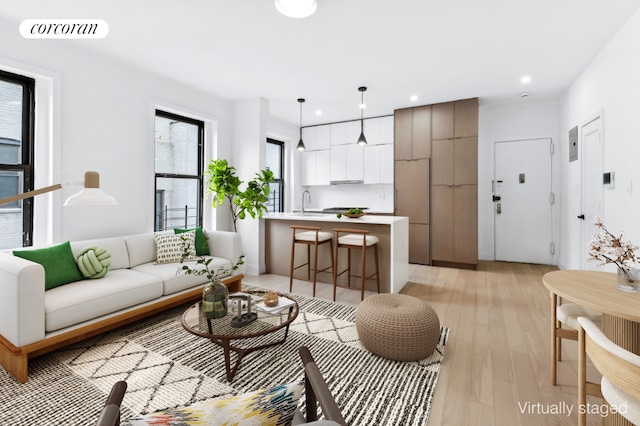 living room featuring light wood-type flooring and sink