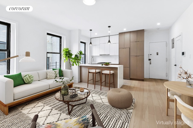 living area featuring light wood-type flooring, visible vents, and recessed lighting