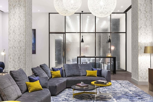 living area with a chandelier, an accent wall, wood finished floors, and floor to ceiling windows