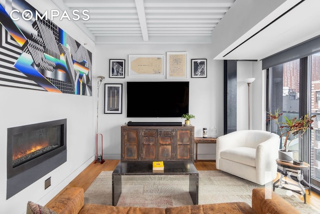 living room with beam ceiling and light hardwood / wood-style flooring