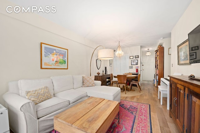 living room featuring an inviting chandelier and light hardwood / wood-style flooring