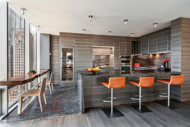 kitchen with appliances with stainless steel finishes, a kitchen bar, and kitchen peninsula