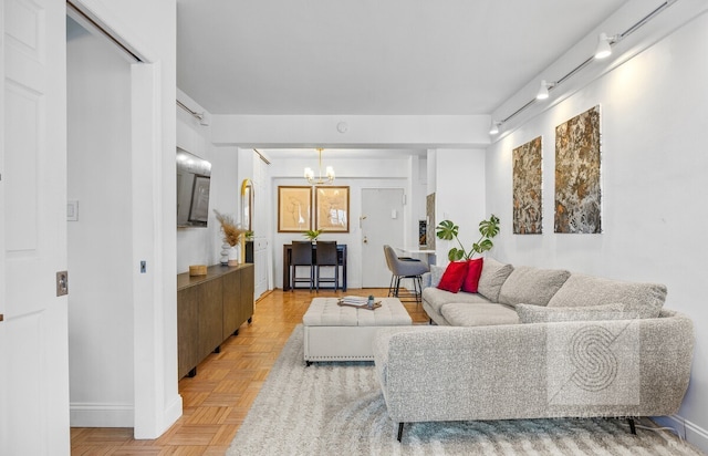 living room with baseboards and a notable chandelier