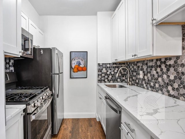 kitchen featuring dark wood finished floors, tasteful backsplash, stainless steel appliances, and a sink