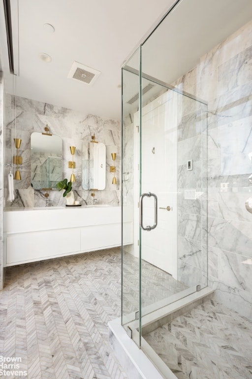 bathroom featuring vanity and a shower with door