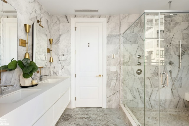 bathroom featuring tasteful backsplash, vanity, a shower with door, and tile walls