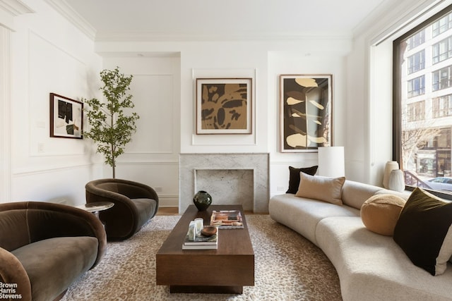 living room featuring crown molding and a high end fireplace