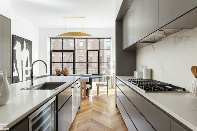 kitchen with pendant lighting, sink, gray cabinets, light parquet floors, and wine cooler