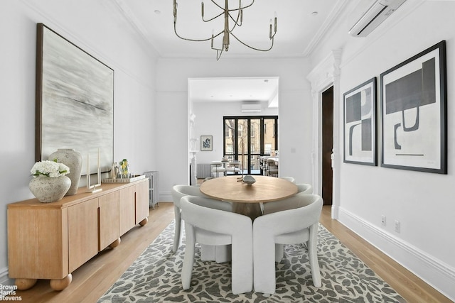 dining space with ornamental molding, an AC wall unit, an inviting chandelier, and light hardwood / wood-style flooring