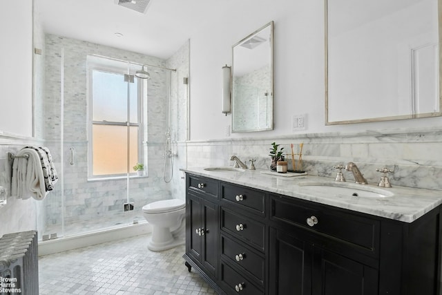 bathroom featuring radiator, tile walls, vanity, an enclosed shower, and toilet