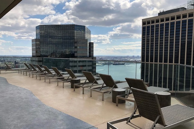 view of patio featuring a balcony and a water view