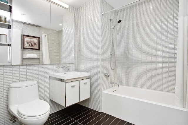 bathroom featuring tile walls, shower / bath combination with curtain, toilet, vanity, and tile patterned floors