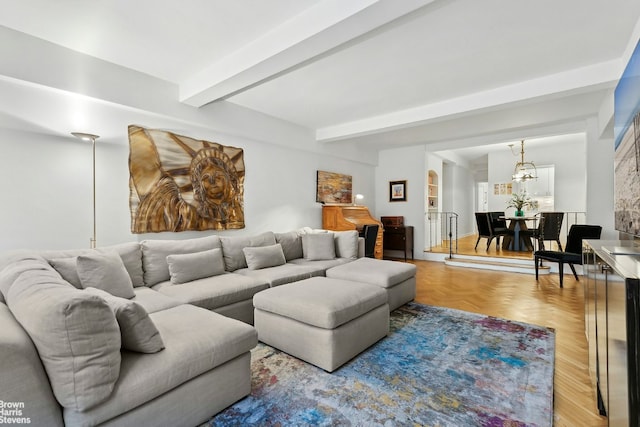 living room featuring parquet floors, a notable chandelier, and beam ceiling