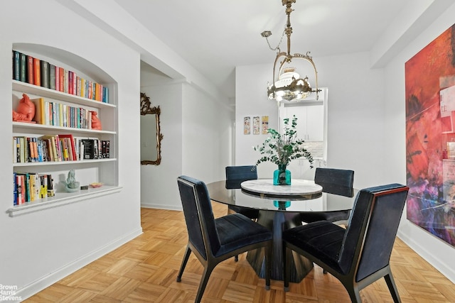 dining room featuring light parquet floors and a notable chandelier