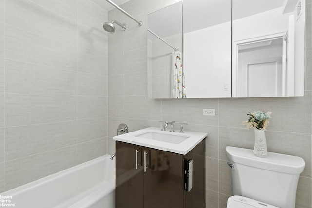 full bathroom featuring toilet, vanity, shower / bath combination with curtain, and tile walls