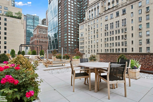 view of patio featuring outdoor dining area and a city view