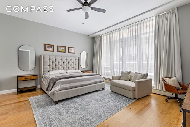 bedroom with ceiling fan, light wood finished floors, and baseboards