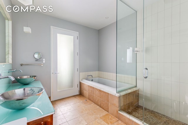 bathroom featuring a bath, tile patterned flooring, a sink, and a shower stall