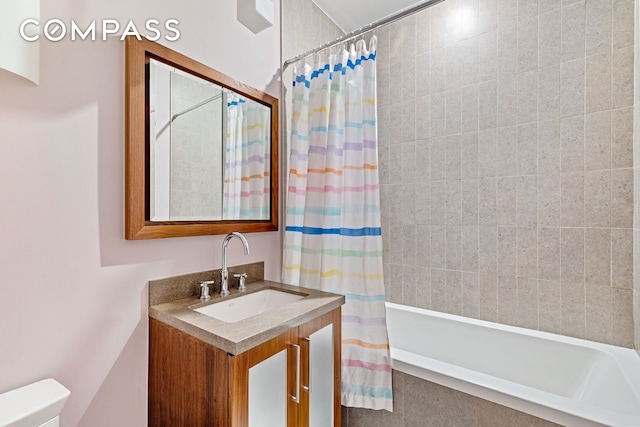 bathroom featuring toilet, tiled shower / bath, and vanity