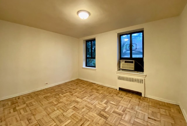 spare room featuring cooling unit, baseboards, and radiator heating unit