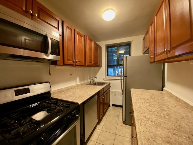 kitchen with light tile patterned floors, brown cabinetry, stainless steel appliances, light countertops, and a sink