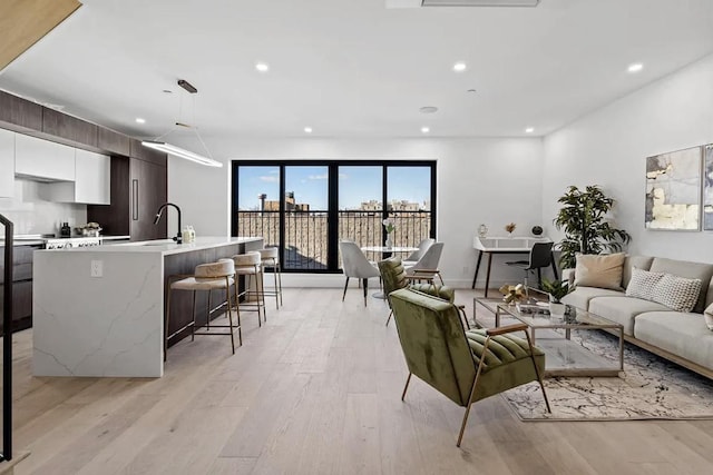 living area featuring light wood-type flooring and recessed lighting