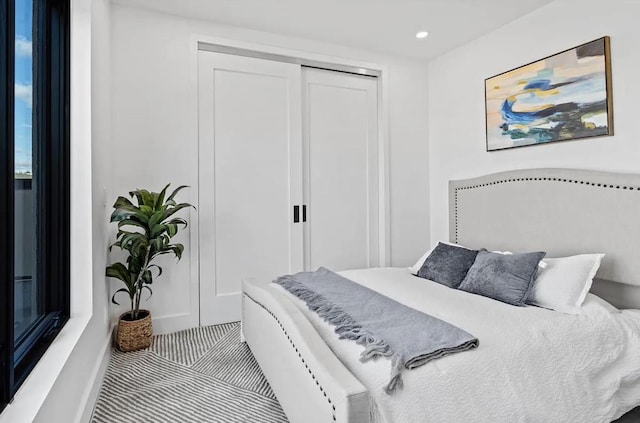 bedroom with light carpet, a closet, and recessed lighting