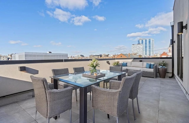 view of patio featuring outdoor lounge area, outdoor dining area, and a city view