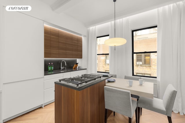 kitchen with visible vents, a sink, dark countertops, beamed ceiling, and modern cabinets