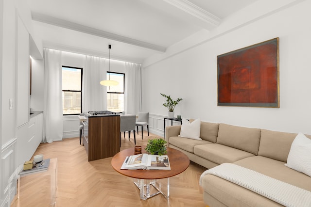 living room with beamed ceiling, wainscoting, ornamental molding, and a decorative wall