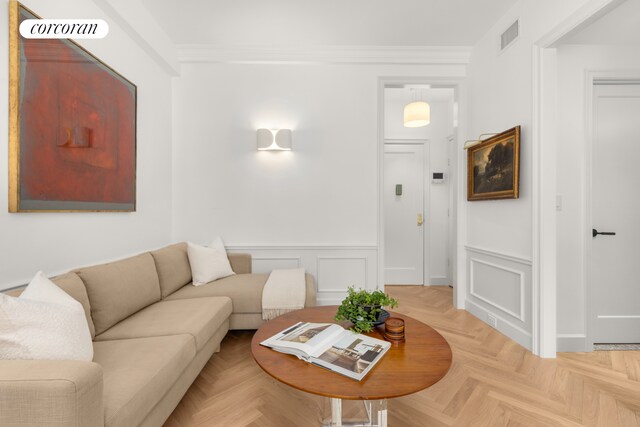 living room featuring crown molding and light parquet floors