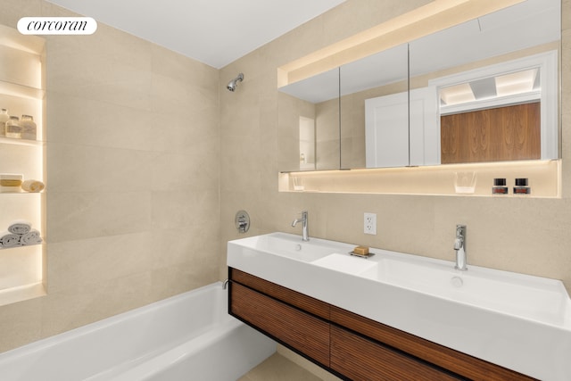 full bath featuring visible vents, a sink, tile walls, and double vanity