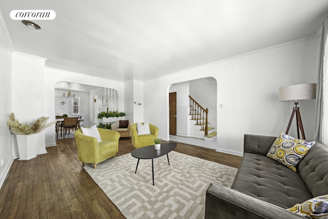 living room with an inviting chandelier, crown molding, and wood-type flooring