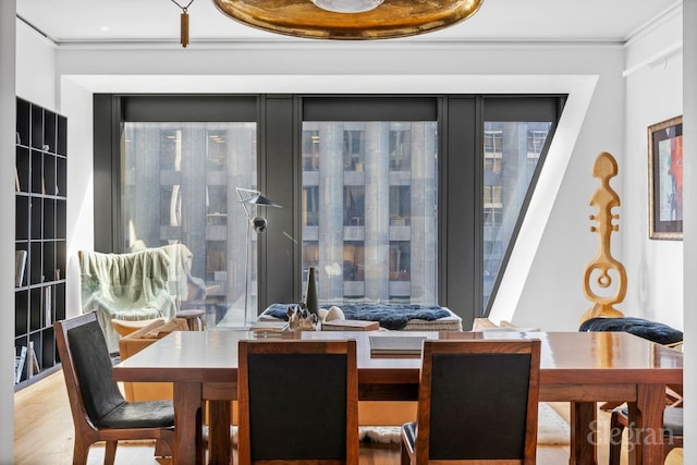 dining space featuring hardwood / wood-style flooring and ornamental molding