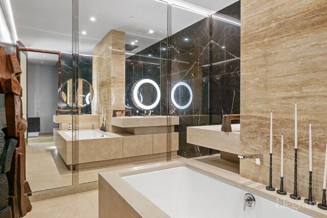 bathroom featuring tile patterned flooring, vanity, and a relaxing tiled tub