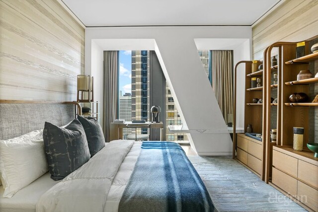 bedroom with wooden walls and light hardwood / wood-style floors