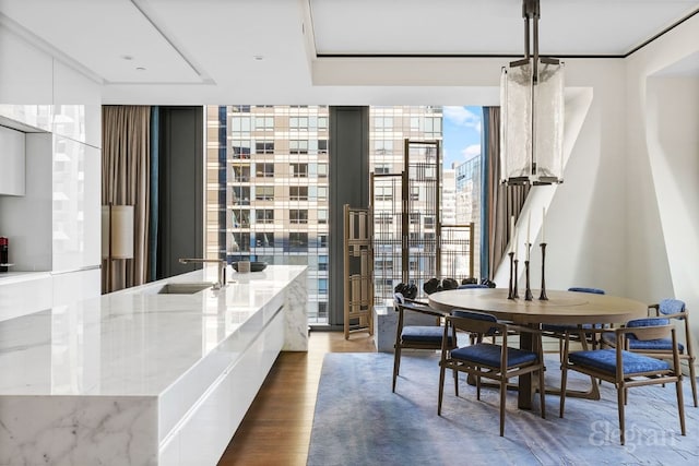 dining room with hardwood / wood-style flooring and a wall of windows