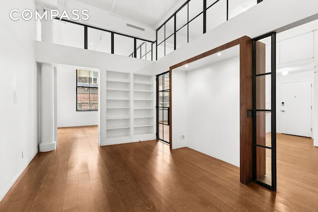 empty room featuring hardwood / wood-style floors and a high ceiling