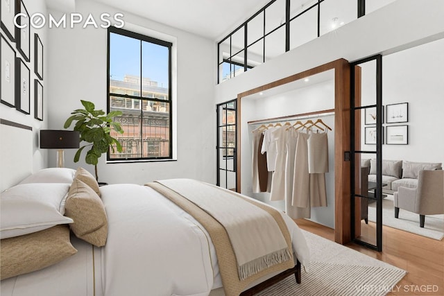 bedroom featuring hardwood / wood-style floors and a towering ceiling